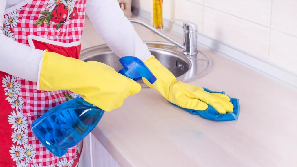 عاملة نظافة تقوم بتنظيف وتلميع رخام المطبخ